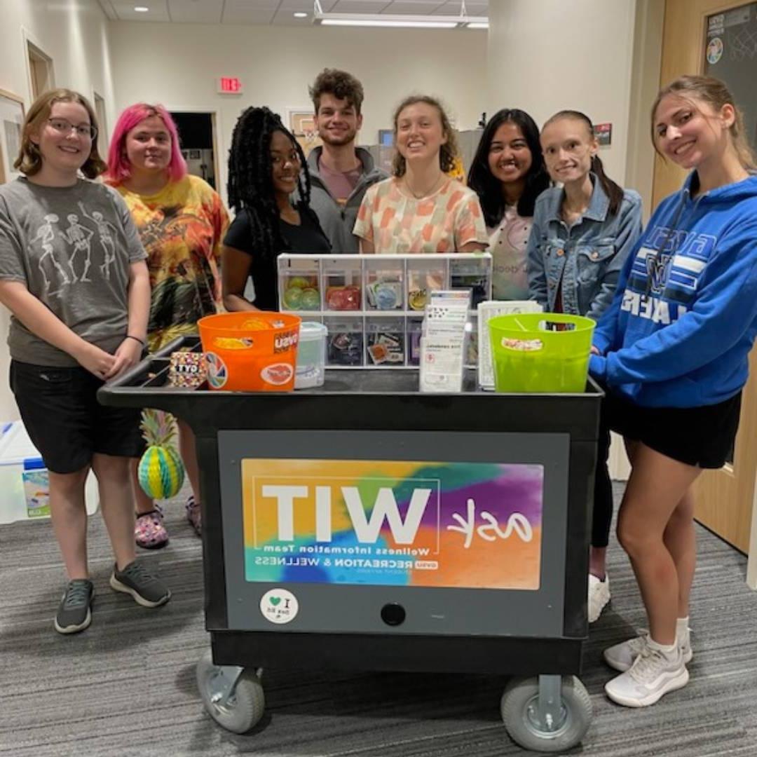 Group of peer educators posing behind the WIT cart